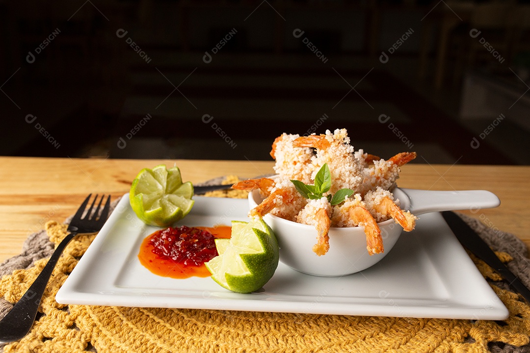 Prato de fritos com molho sobre mesa de restaurante