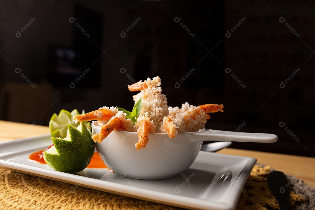 Prato de fritos com molho sobre mesa de restaurante