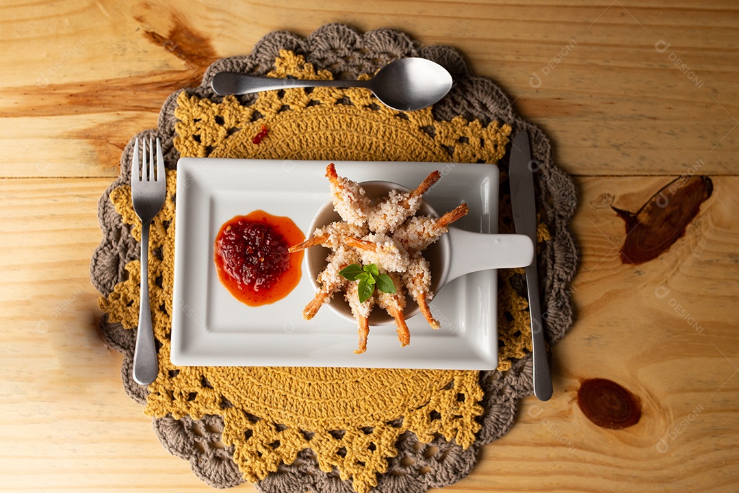 Prato de fritos com molho sobre mesa de restaurante