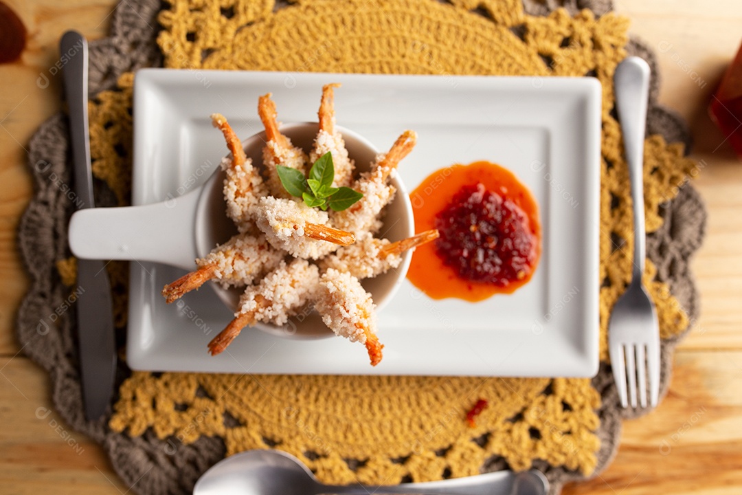 Prato de fritos com molho sobre mesa de restaurante