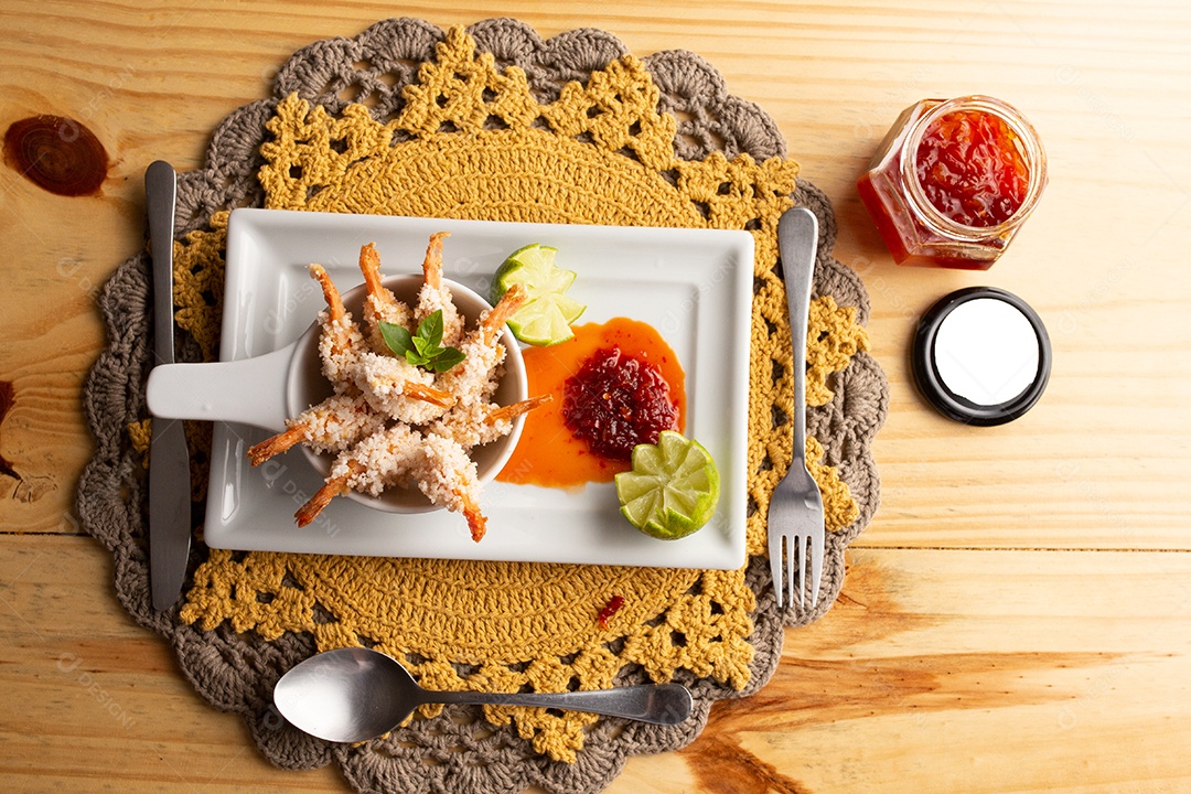 Prato de fritos com molho sobre mesa de restaurante