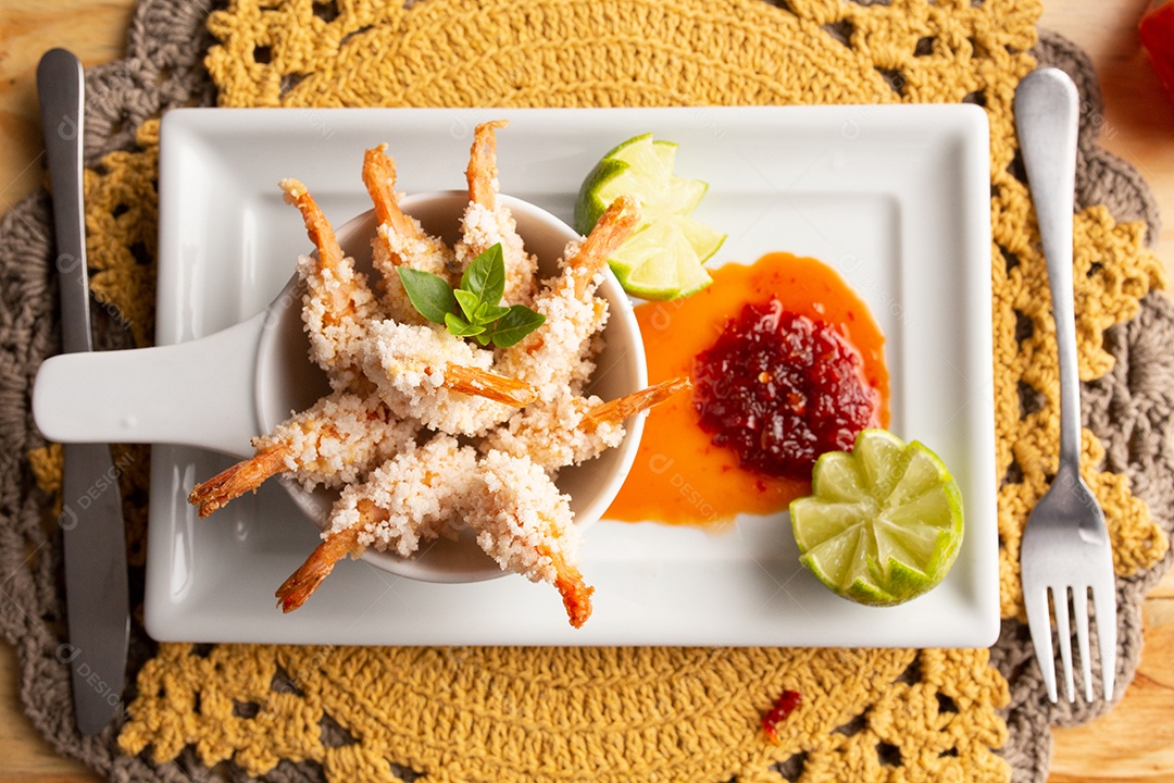 Prato de fritos com molho sobre mesa de restaurante