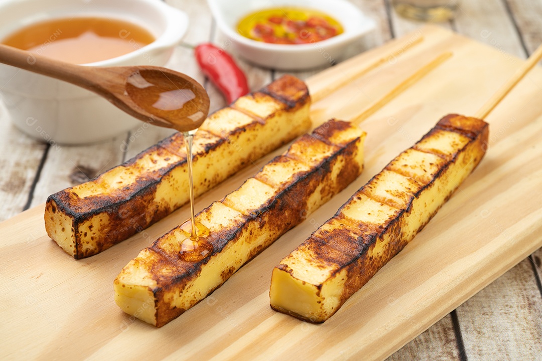 Queijo Coalho ou Coalho grelhado em tábua de madeira com calda de açúcar e pimenta.