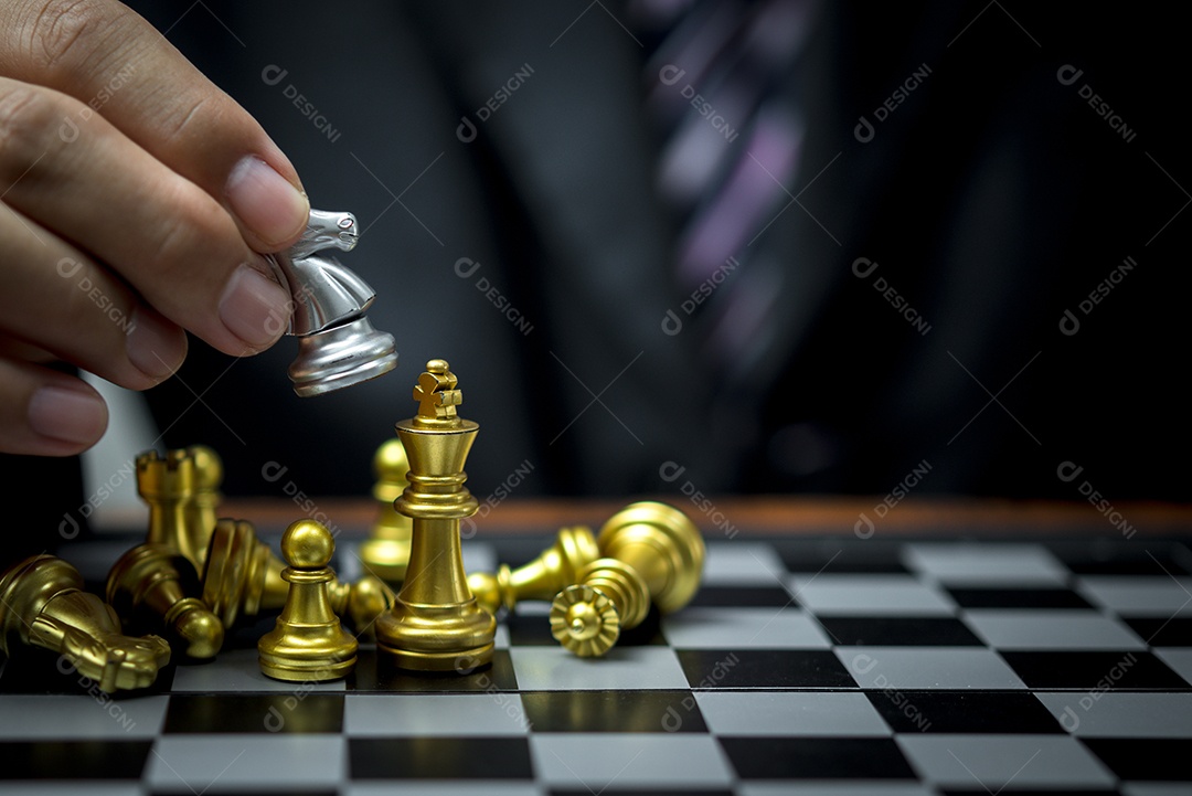 Mão do empresário movendo a figura de xadrez no jogo de sucesso da competição.