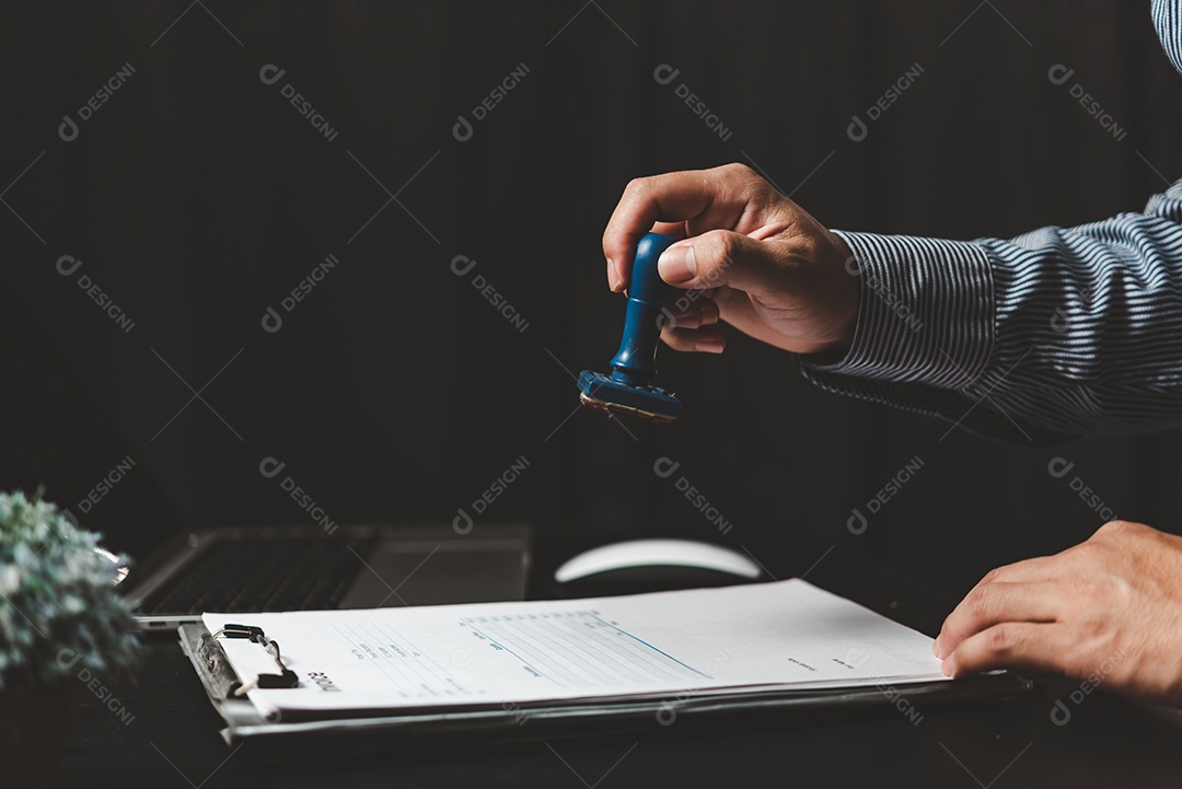 Homem carimbando a aprovação de documentos bancários de finanças de trabalho