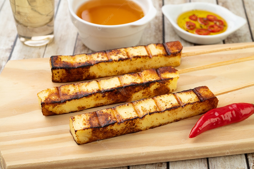 Queijo Coalho ou Coalho grelhado em tábua de madeira com calda de açúcar e pimenta.