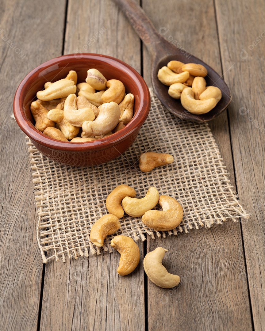 Castanha de caju em uma tigela sobre a mesa de madeira.