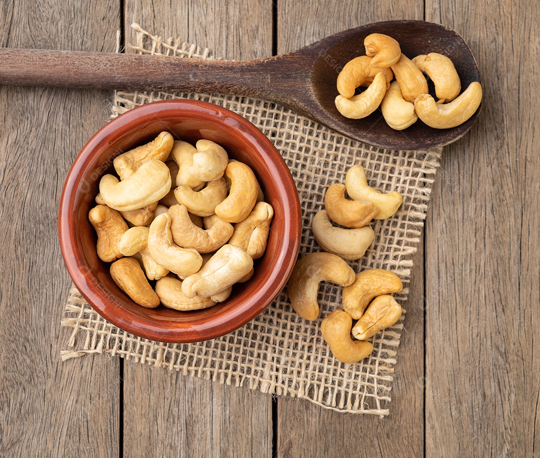 Castanha de caju em uma tigela sobre a mesa de madeira.