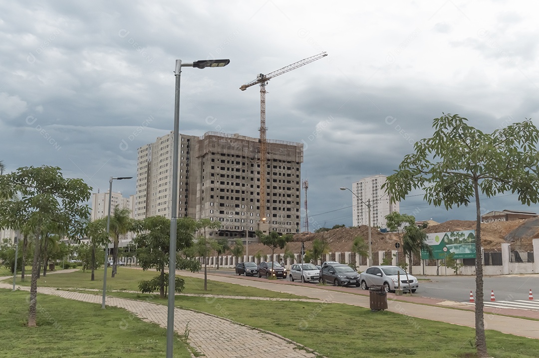 Edifício sendo construído com um guindaste de construção ao lado.