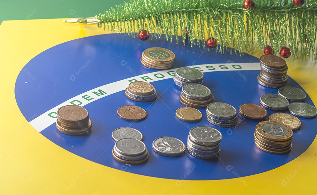 Ordem progresso bandeira brasileira com moedas reais brasileiras, conceito de decadência do dinheiro brasileiro.