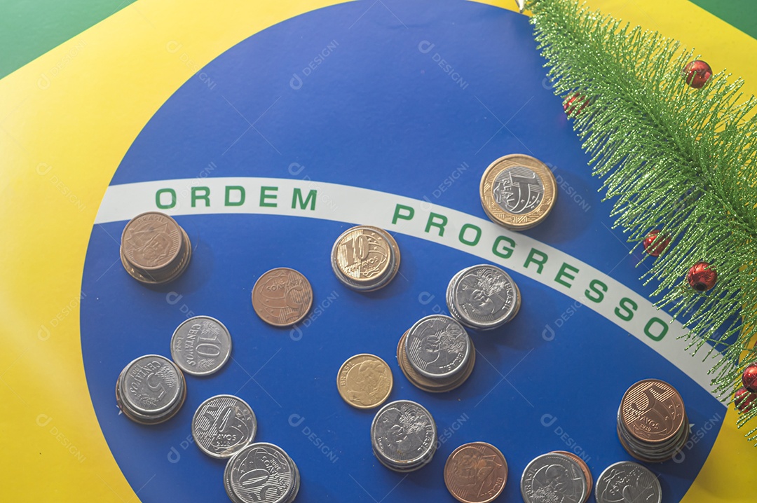 Ordem progresso bandeira brasileira com moedas reais brasileiras, conceito de decadência do dinheiro brasileiro.