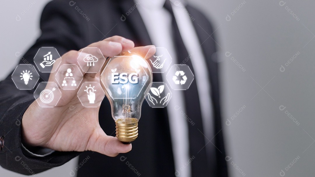 Mão de empresário segurando lâmpada com ícone esg no scr virtual