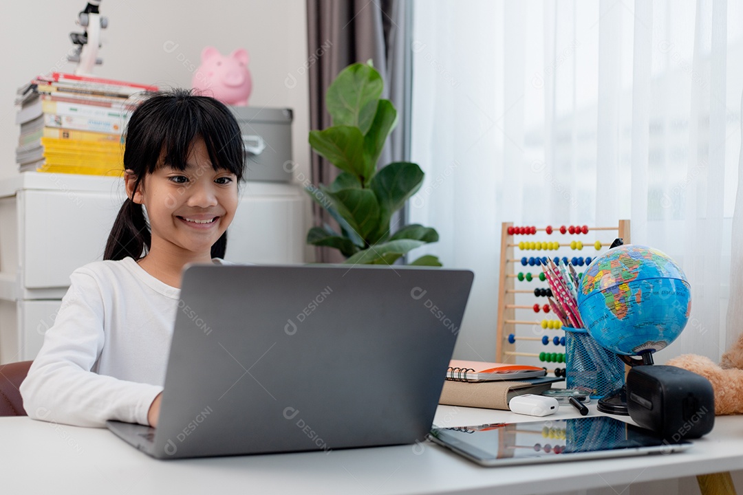 Aluna asiática fazendo sua lição de casa com o laptop em casa