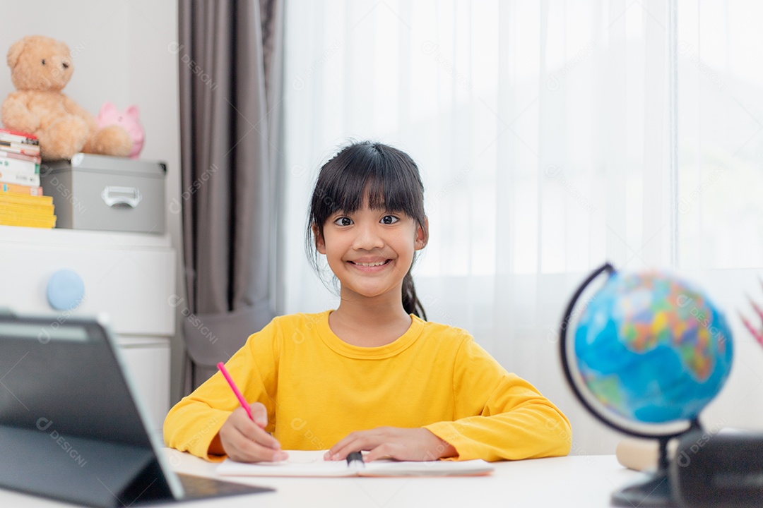 Aluna asiática fazendo sua lição de casa com o laptop em casa