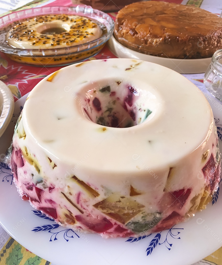 Gelatina colorida, mousse de maracujá, creme de coco e torta de maçã. Mesa de famosos doces brasileiros.