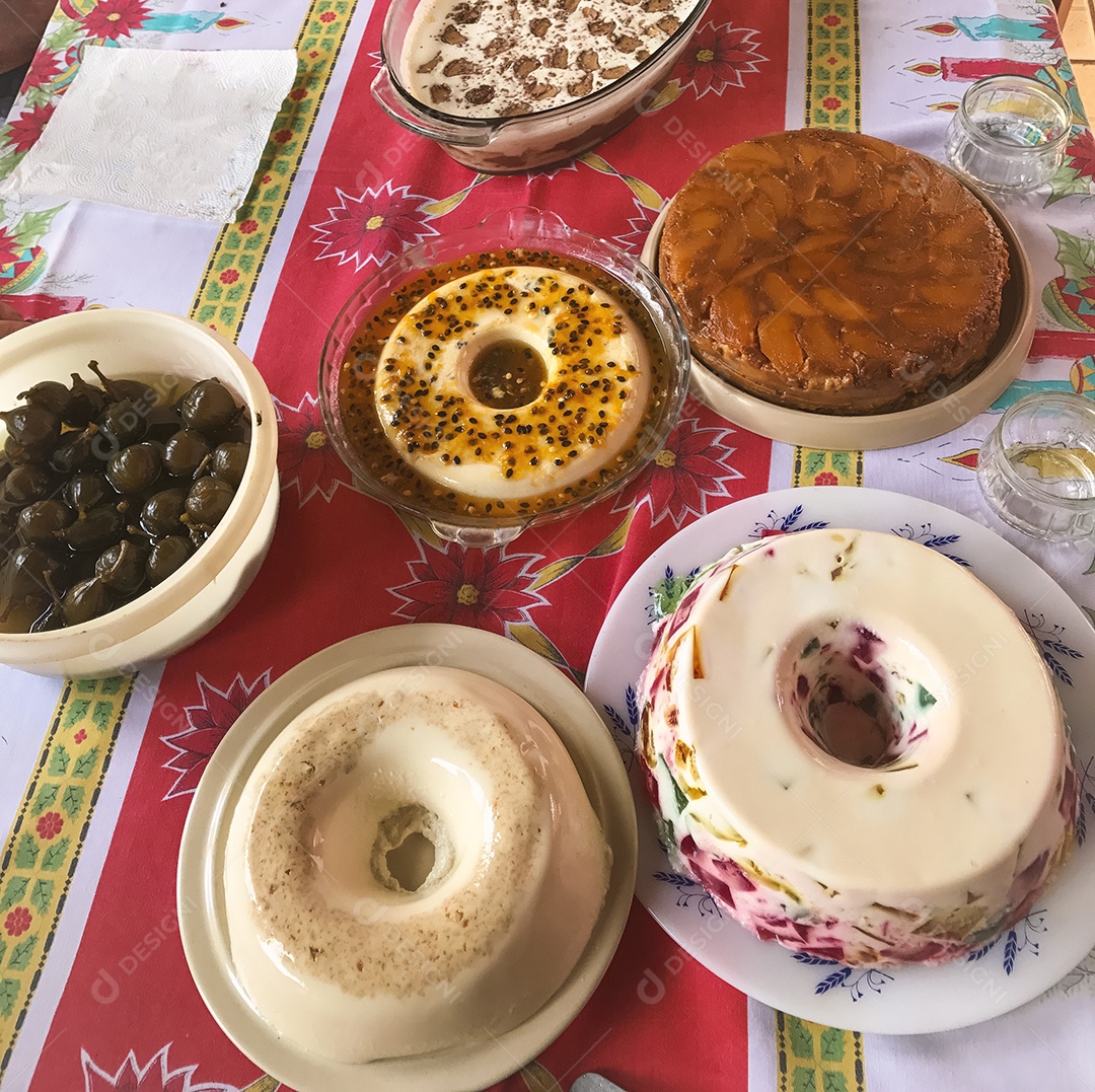 Gelatina colorida, mousse de maracujá, creme de coco e torta de maçã. Mesa de famosos doces brasileiros.
