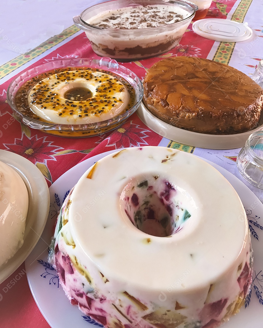 Gelatina colorida, mousse de maracujá, creme de coco e torta de maçã. Mesa de famosos doces brasileiros.