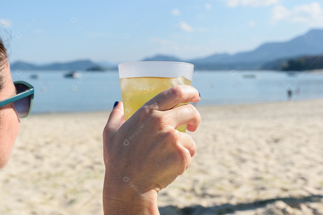 Mulher da praia de Tabatinga relaxando e bebendo vodka com energético