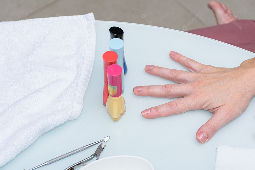 Manicure com palito de madeira com algodão para limpar a cutícula da cliente.