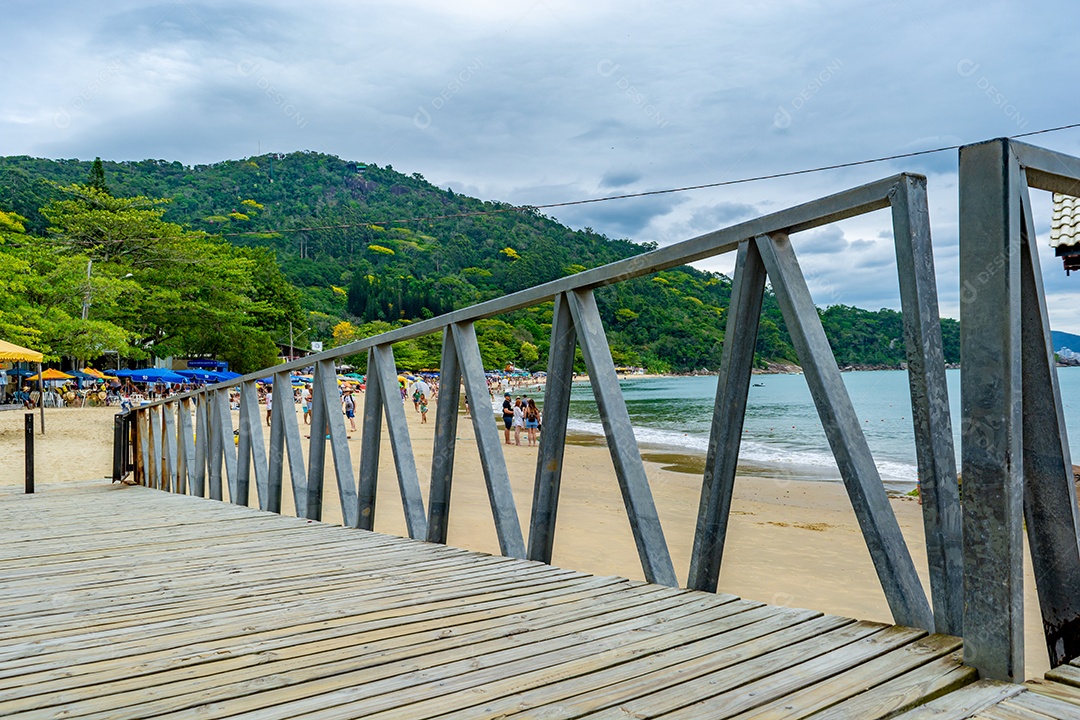 Vista lateral da Praia de Laranjeiras em um dia ensolarado com famílias aproveitando