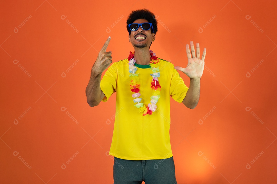 Fã brasileiro de futebol comemorando isolado em fundo laranja. Fã de futebol animado torcendo.