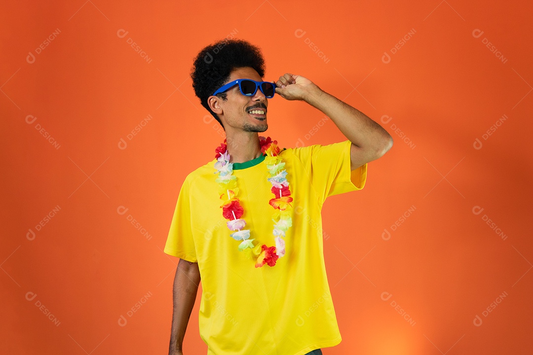 Fã brasileiro de futebol comemorando isolado em fundo laranja. Fã de futebol animado torcendo.