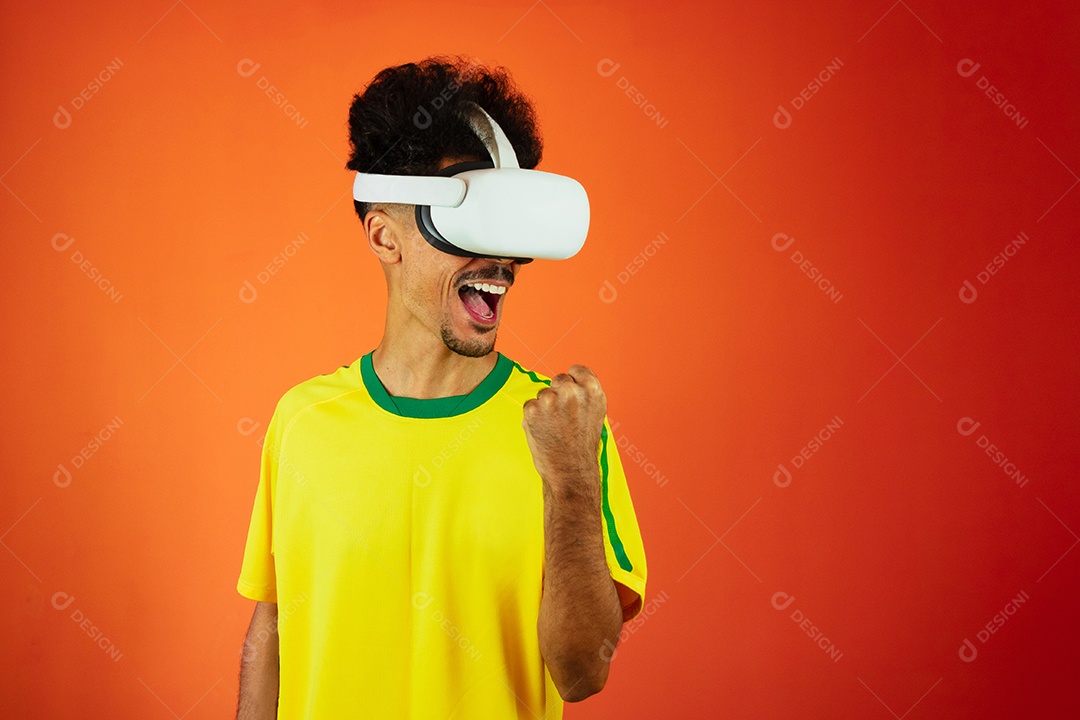 Jogador brasileiro - homem negro comemorando com óculos virtuais isolados em laranja