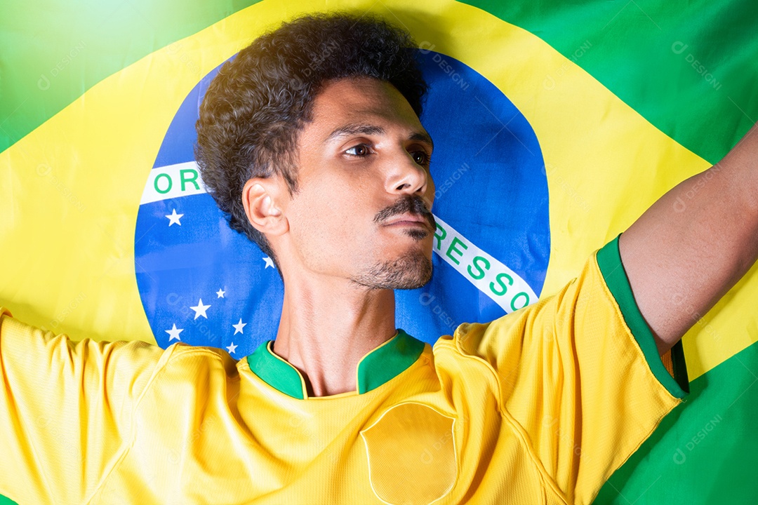 Homem negro segurando a bandeira do Brasil atrás