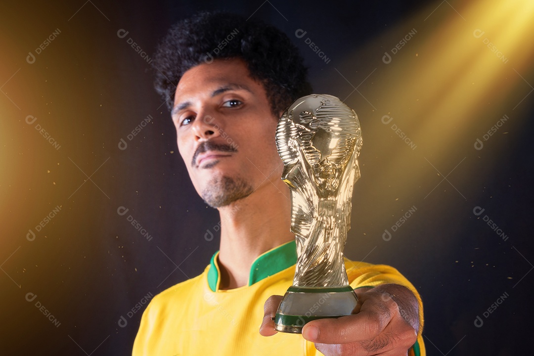 Jogador negro de futebol brasileiro segurando o troféu vencedor