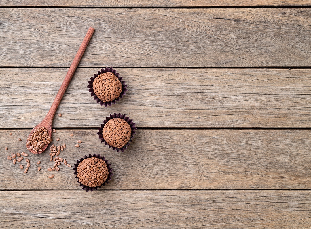 Típicos brigadeiros de chocolate brasileiros sobre mesa de madeira