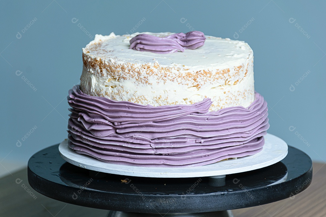 Bolo de creme de manteiga roxo, descansando em uma plataforma giratória.