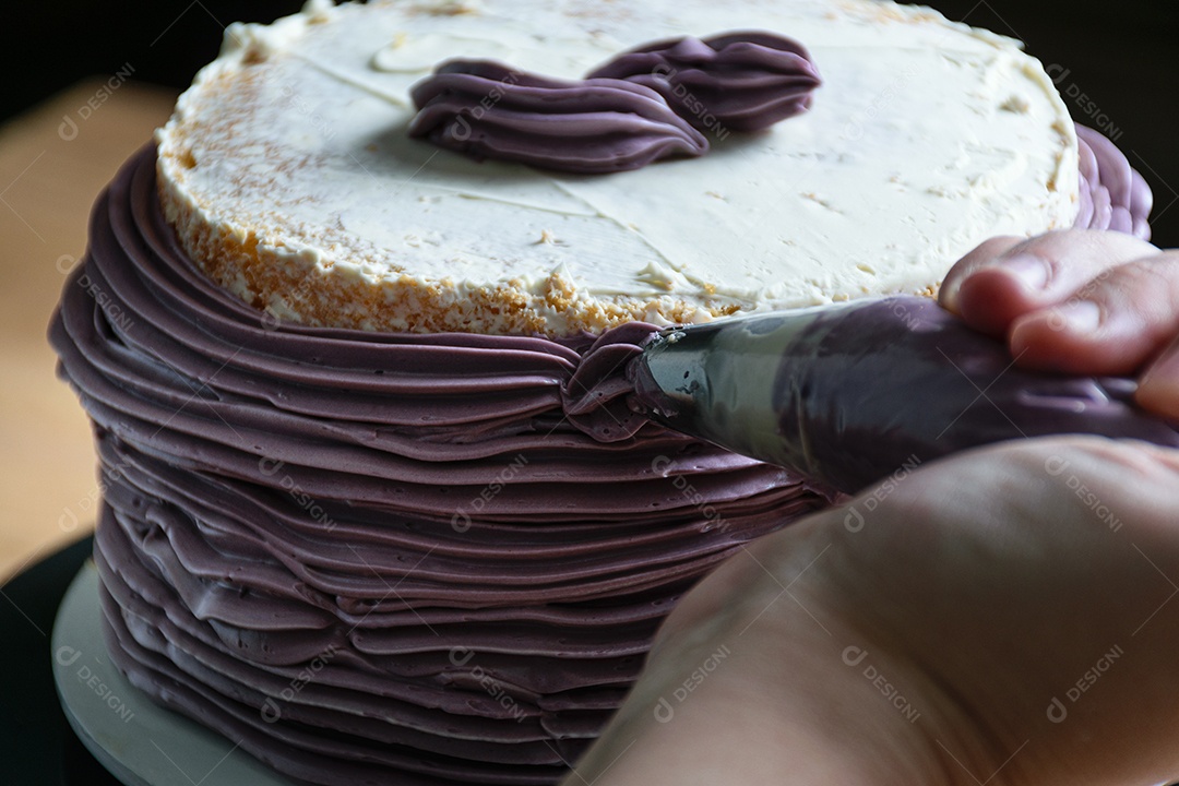 Bico de confeiteiro colocando creme de manteiga no bolo. luz principal