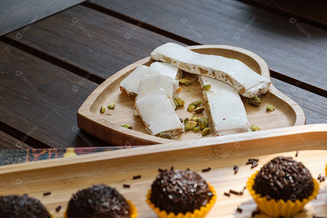 Brigadeiro doce brasileira desfocado pistache na mesa de madeira.