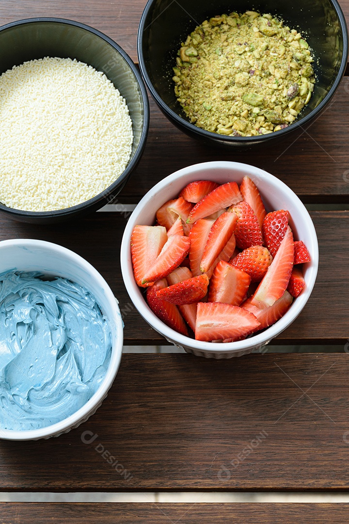 Ingredientes para o bolo, morangos, creme de manteiga azul, granulado de chocolate branco