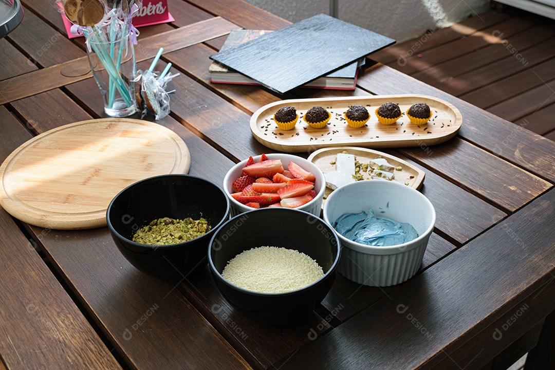 Torrão, brigadeiros e Ingredientes do Bolo na mesa mogangos