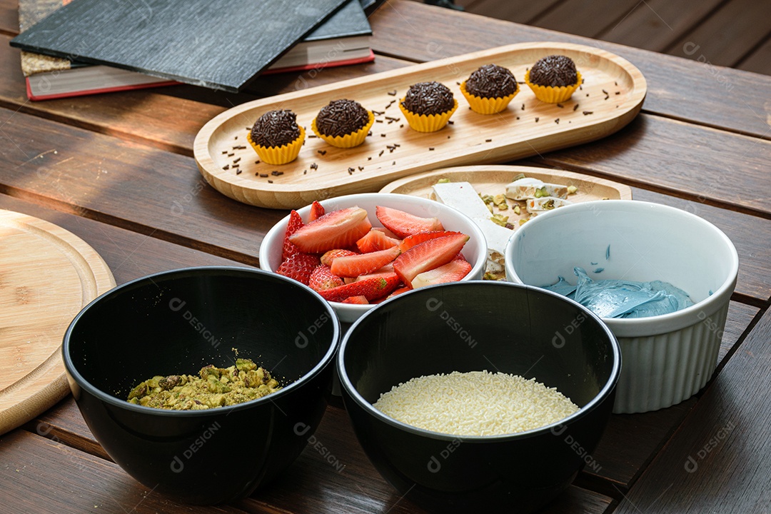Torrão, brigadeiros e Ingredientes do Bolo na mesa mogangos