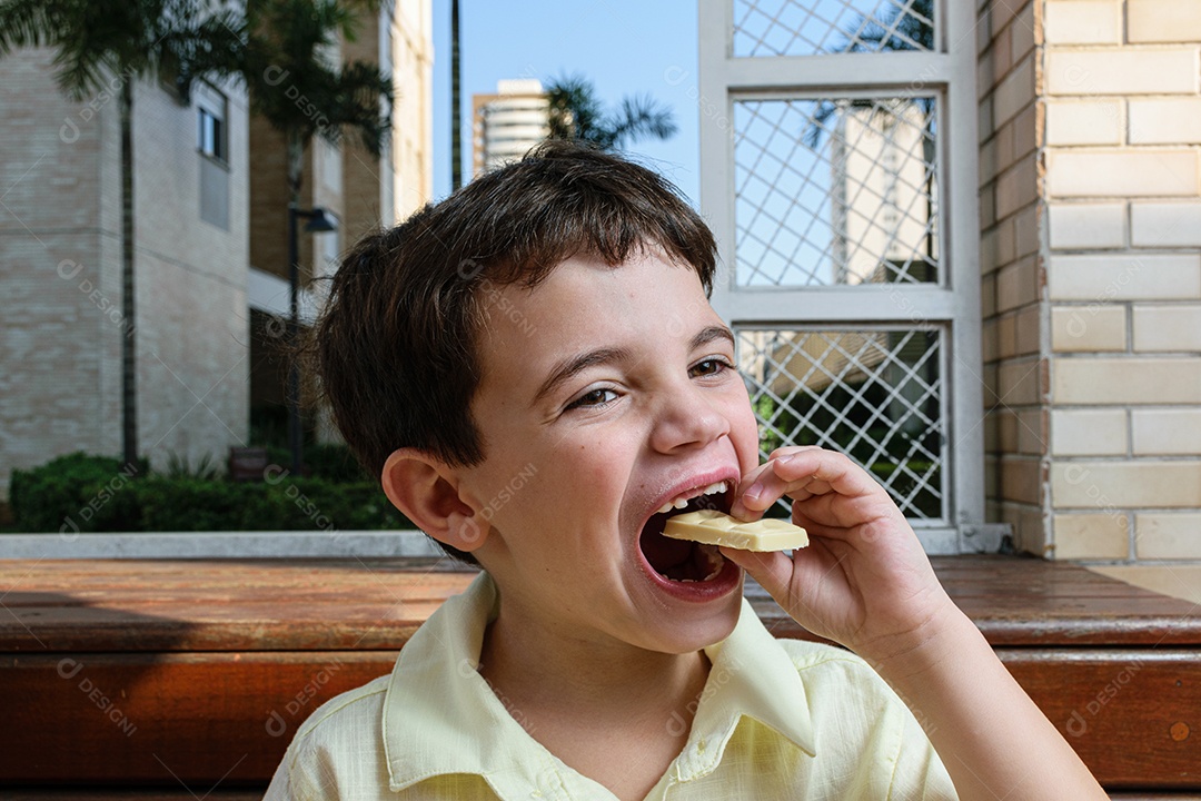 Menino garoto feliz e sorridente se alimentando