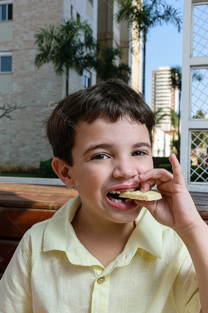 Menino garoto feliz e sorridente se alimentando