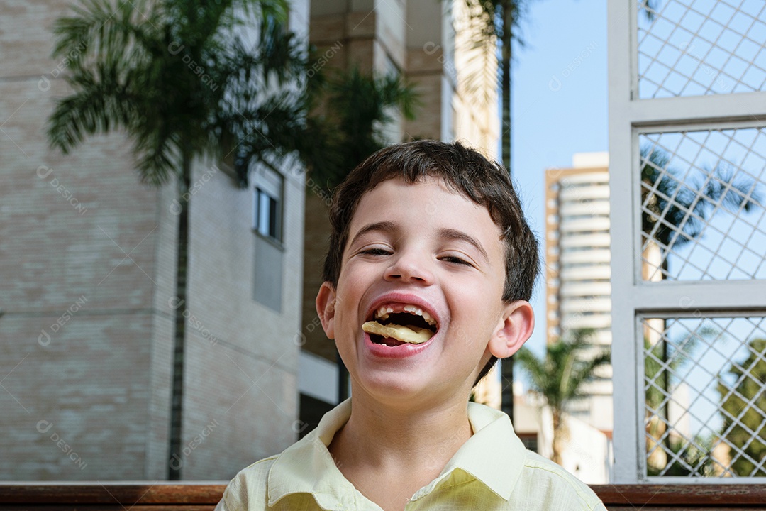 Menino garoto feliz e sorridente se alimentando