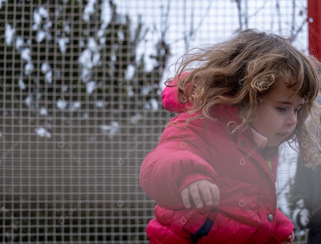 Beautiful blonde girl playing in the snow at the ski resort.