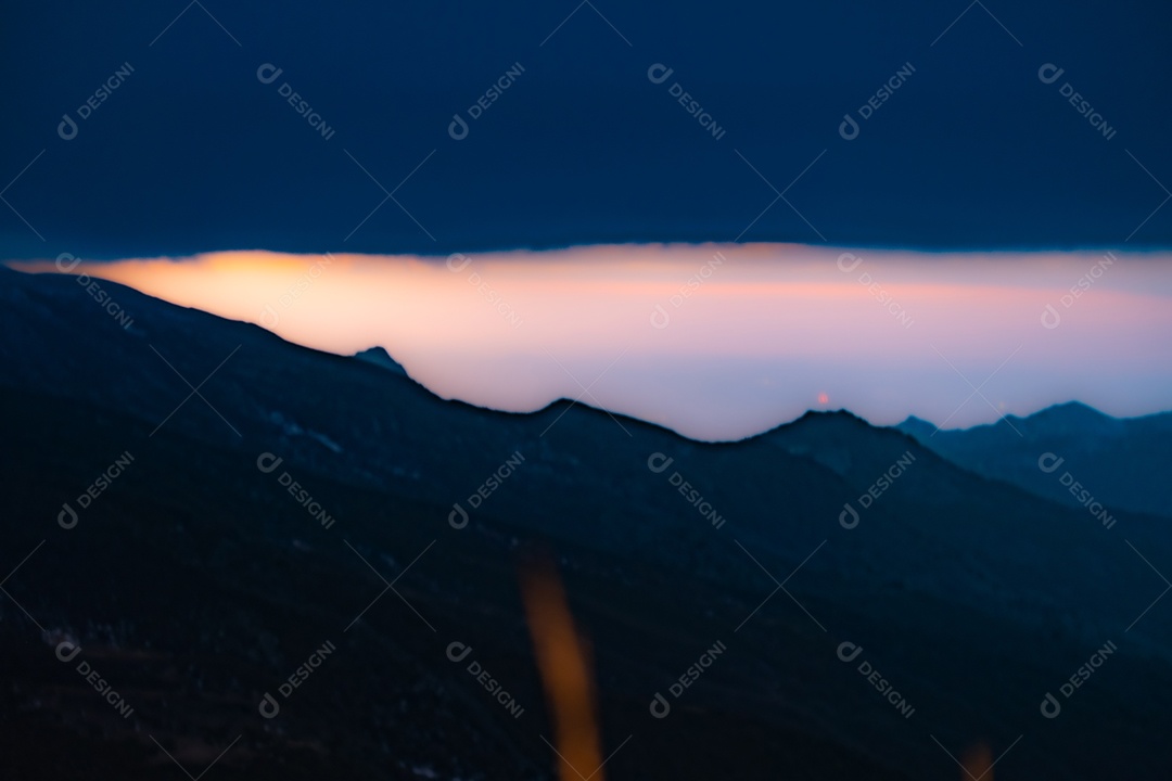 Vista da Serra Nevada com pequena estrada e cidade de Granada ao pôr do sol.