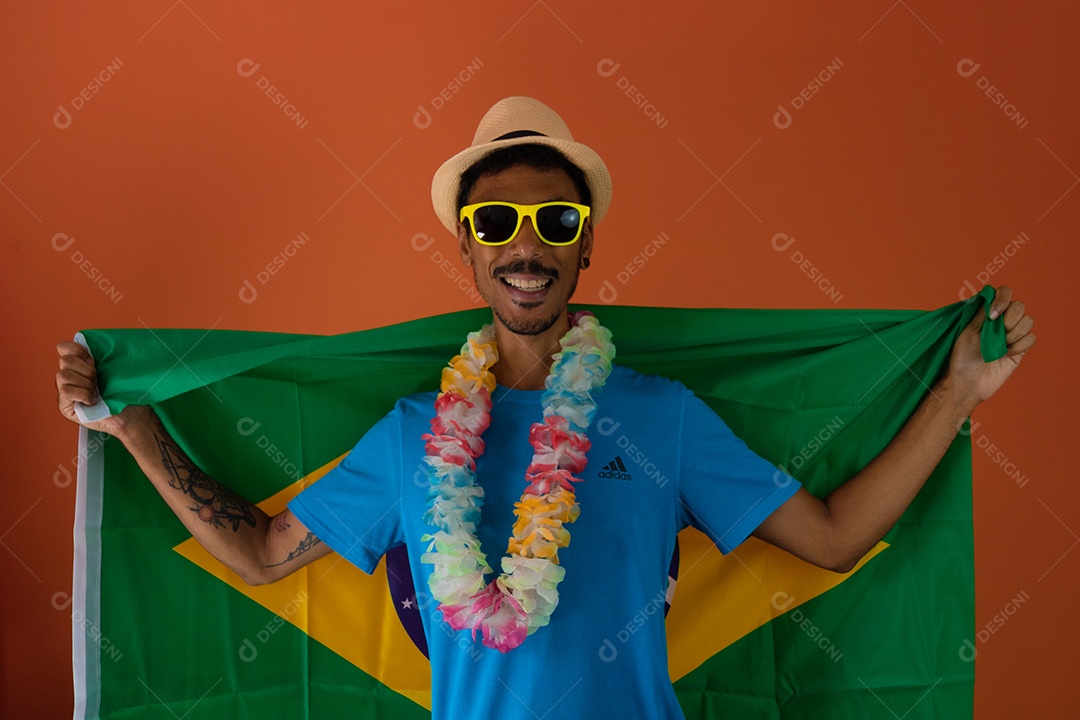 Homem negro fantasiado para o carnaval do brasil isolado em fundo laranja.