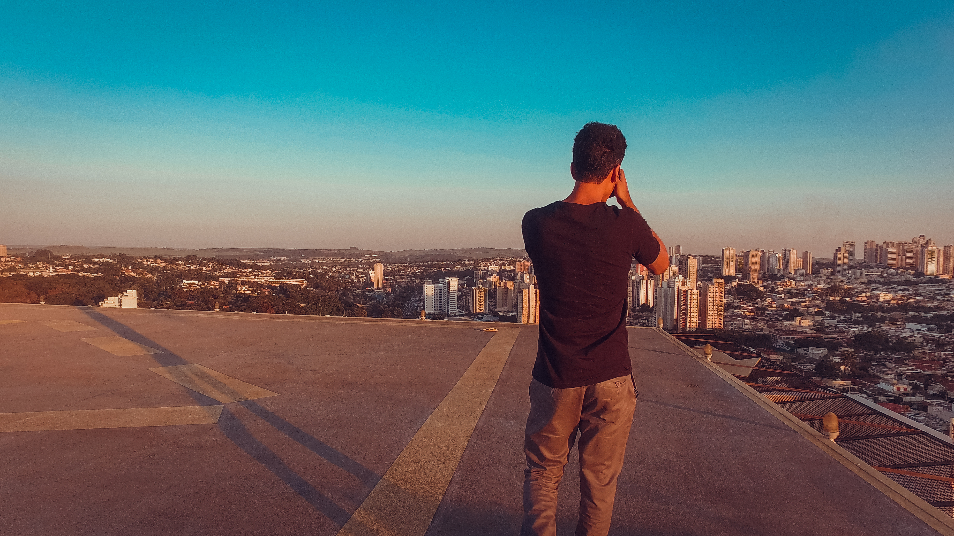 Fotógrafo no topo do prédio ao pôr do sol