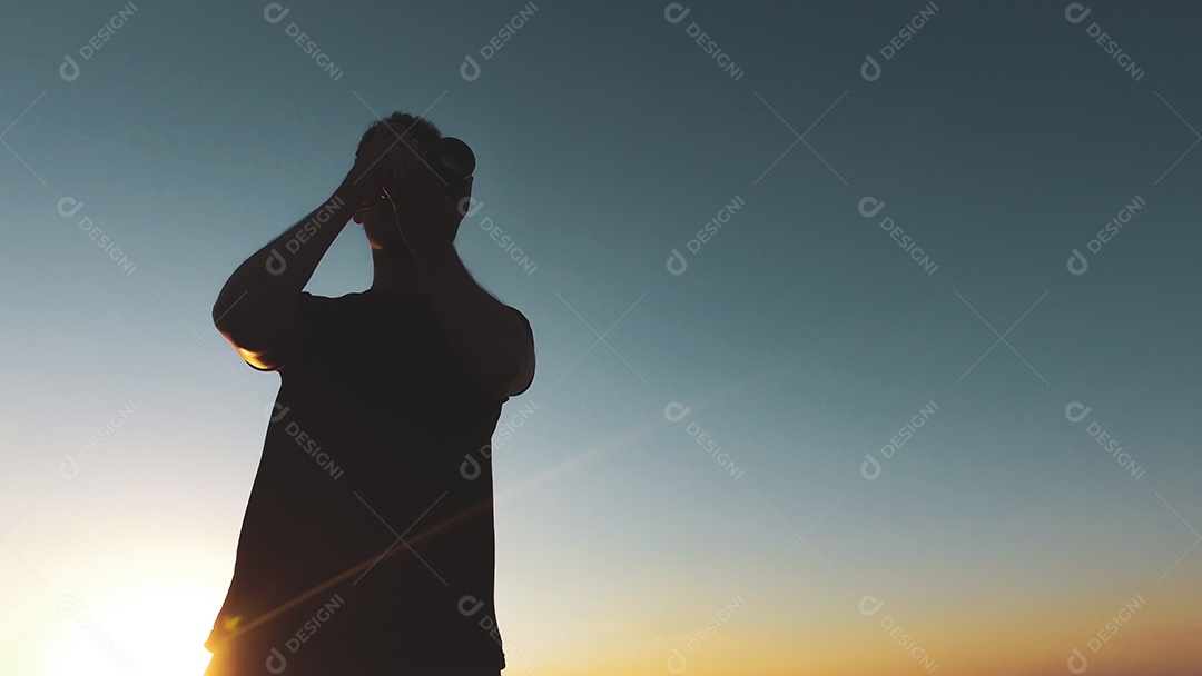 Silhueta de fotógrafo de homem ao pôr do sol