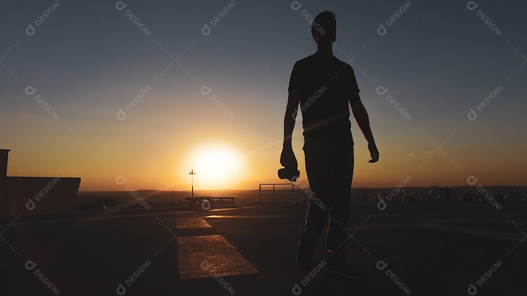 Silhueta de fotógrafo de homem ao pôr do sol
