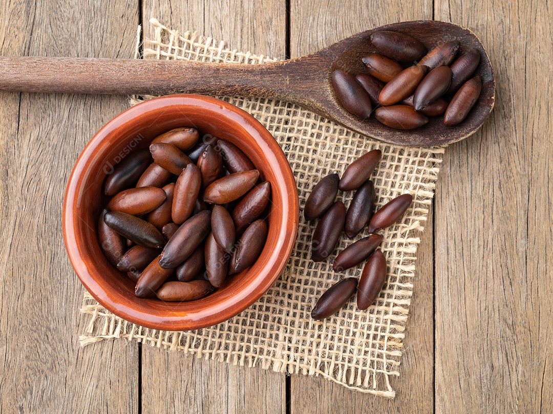 Nozes de baru brasileiras em uma tigela sobre a mesa de madeira.