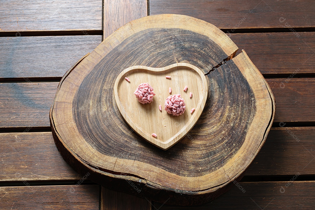 Detalhe de dois brigadeiros de frutas vermelhas. Foco feito no brigadeiro superior.