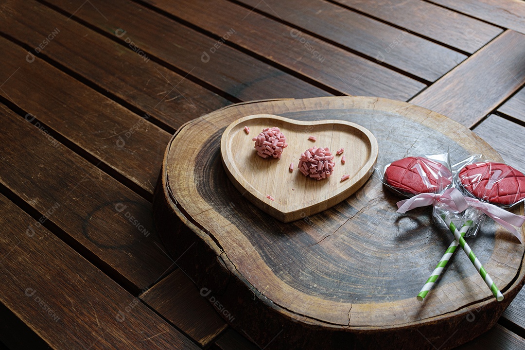 Detalhe de dois brigadeiros de frutas vermelhas. Foco feito no brigadeiro superior.