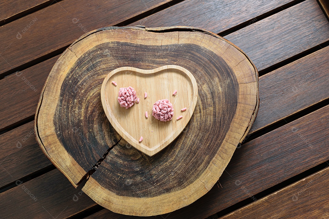 Detalhe de dois brigadeiros de frutas vermelhas. Foco feito no brigadeiro superior.