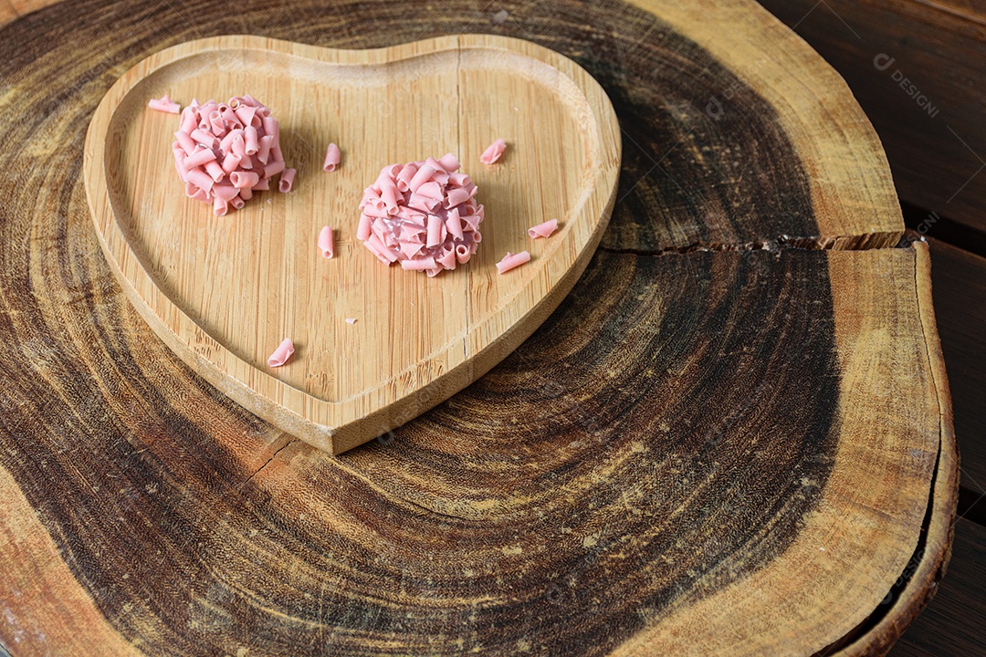 Detalhe de dois brigadeiros de frutas vermelhas. Foco feito no brigadeiro superior.